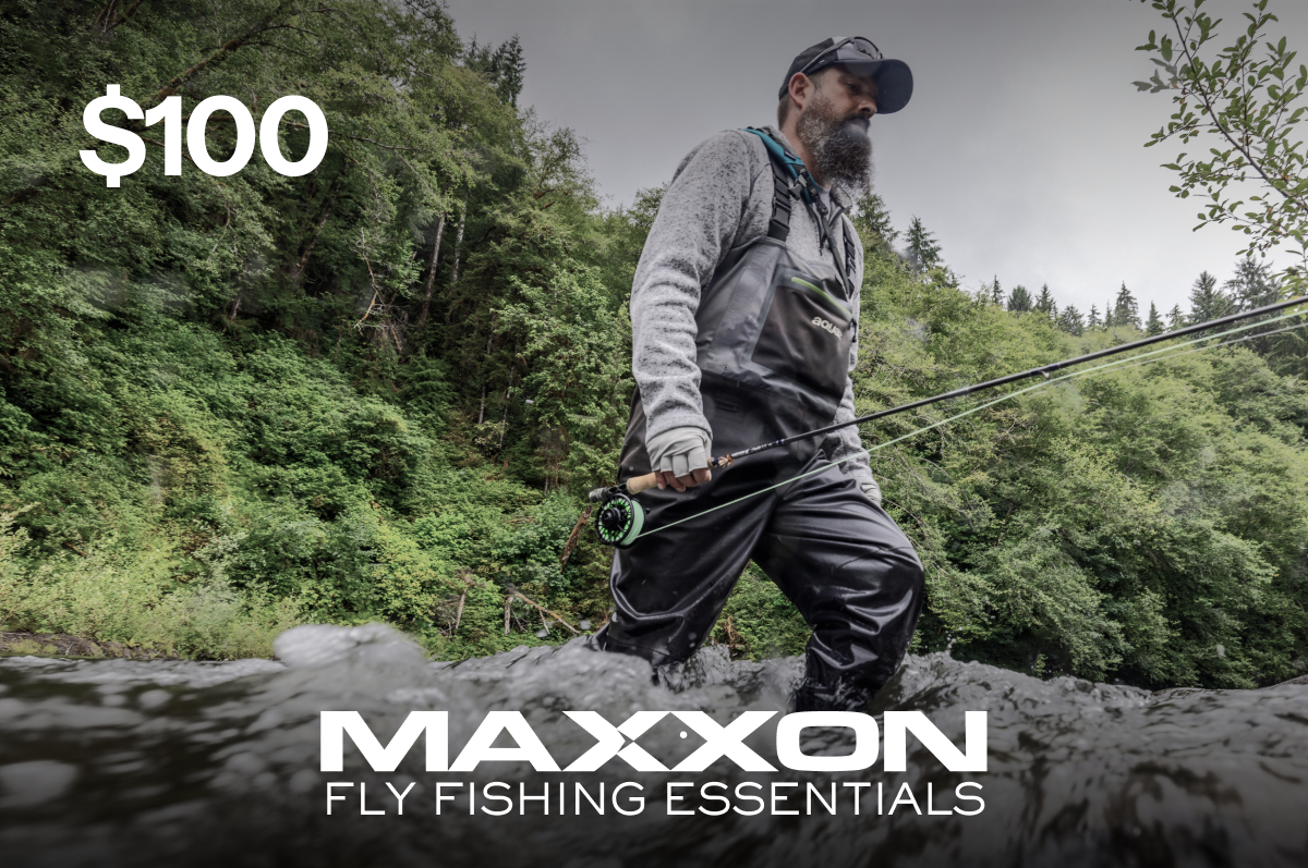 Man in gray waders and black cap fly fishing in river with green reel rod